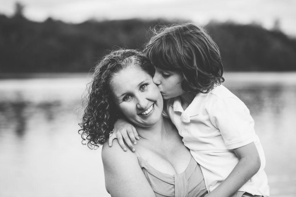 little boy gives his mom a kiss on the cheek