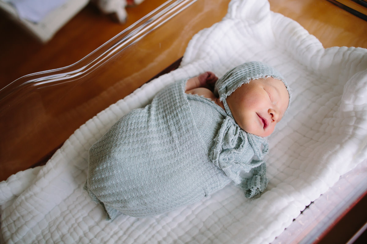 newborn baby swaddled in blue in bassinet fresh 48 session Albany NY