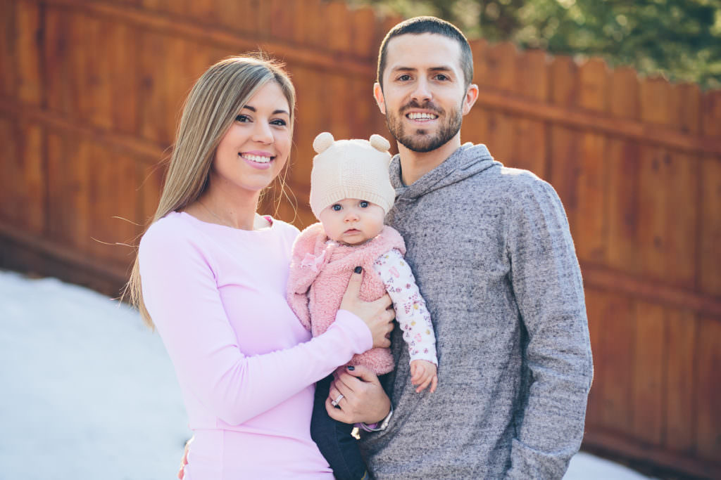 Mom and dad holding baby in snow baby first year session Albany New York