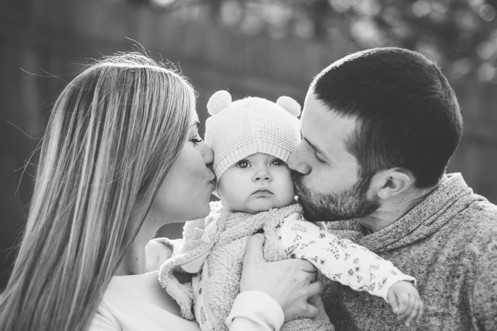Albany NY photographer mom and dad kissing baby in hat