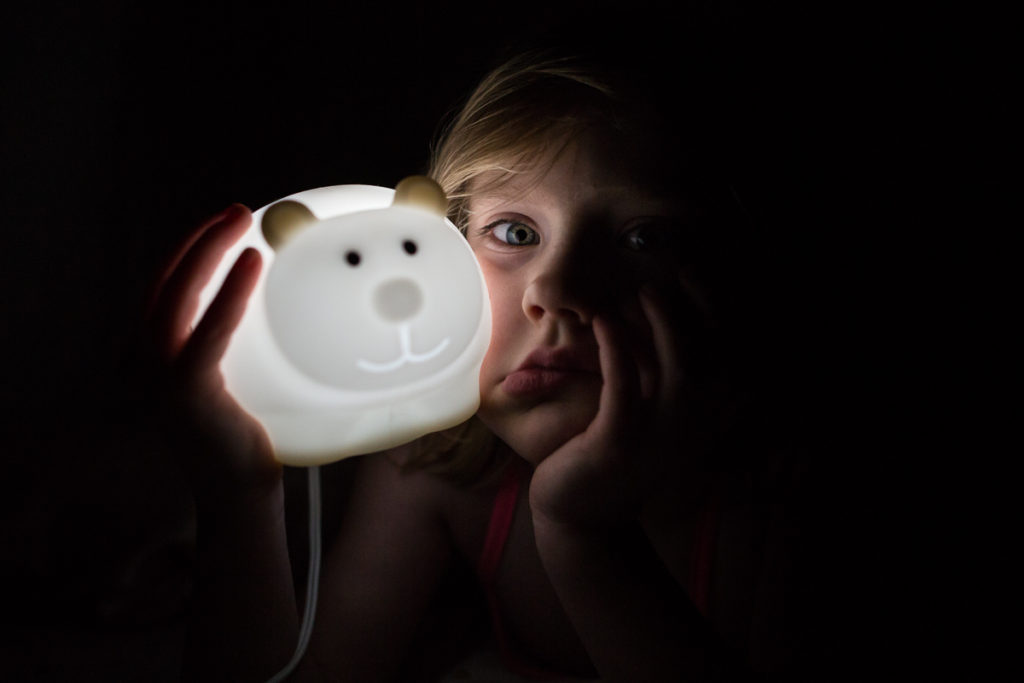 little girl holding a bear night light
