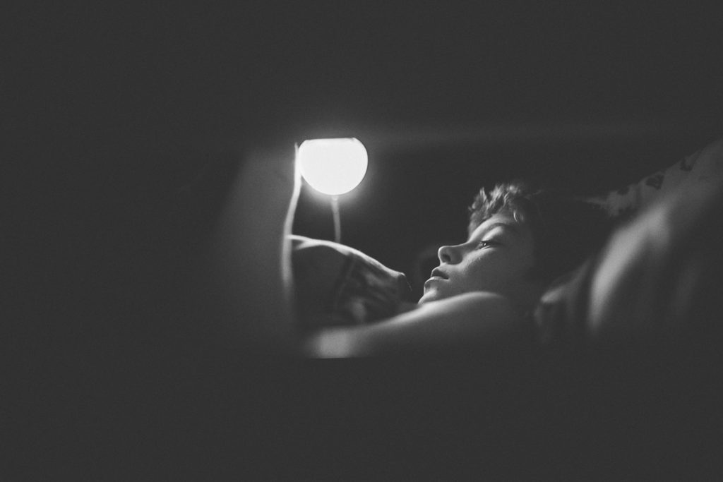 black and white photography boy reading by lamplight