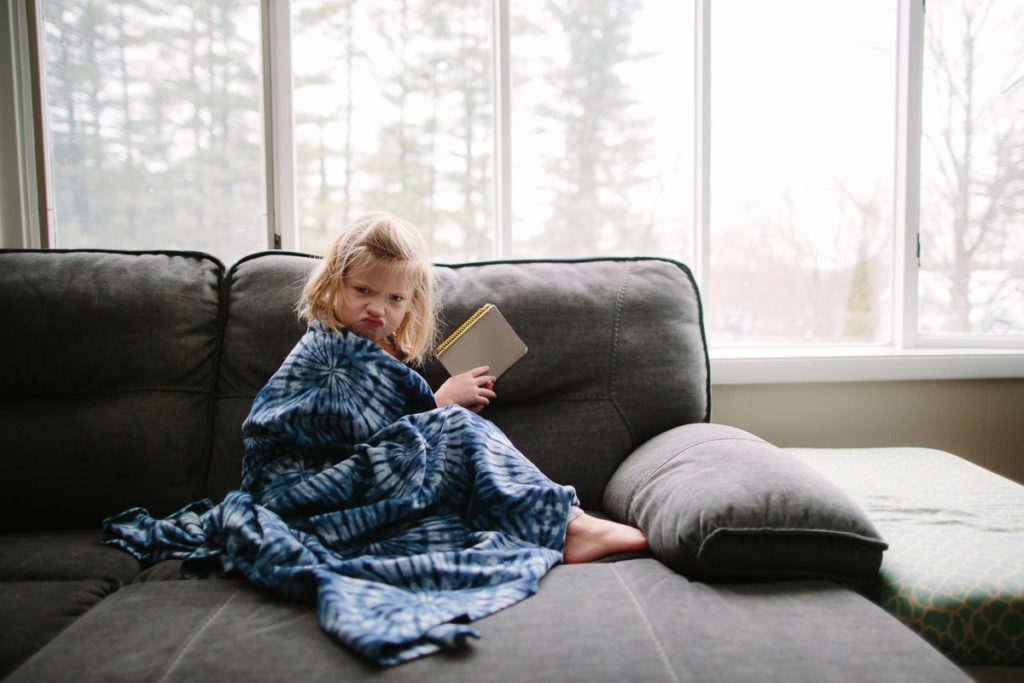 child lifestyle photographer grumpy child in blanket