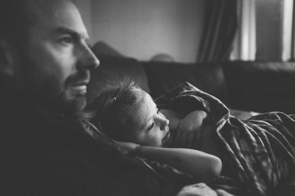 black and white photography child snuggled with dad