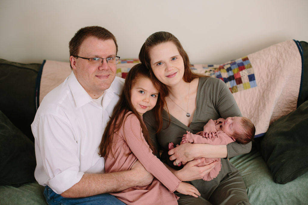family of four with newborn baby girl