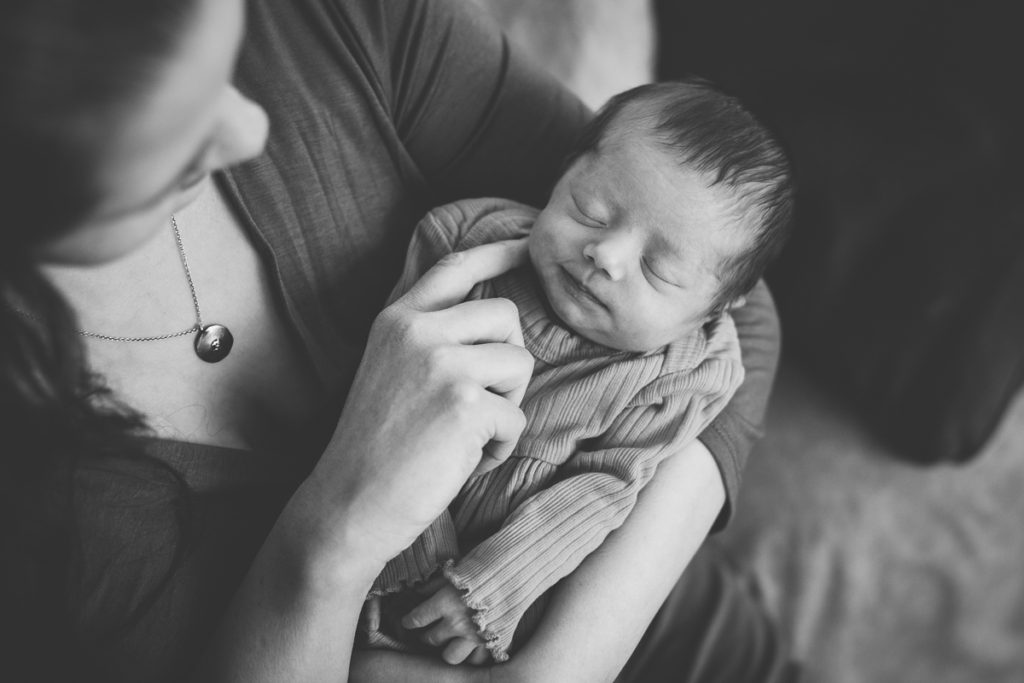 newborn baby girl snuggling with mom