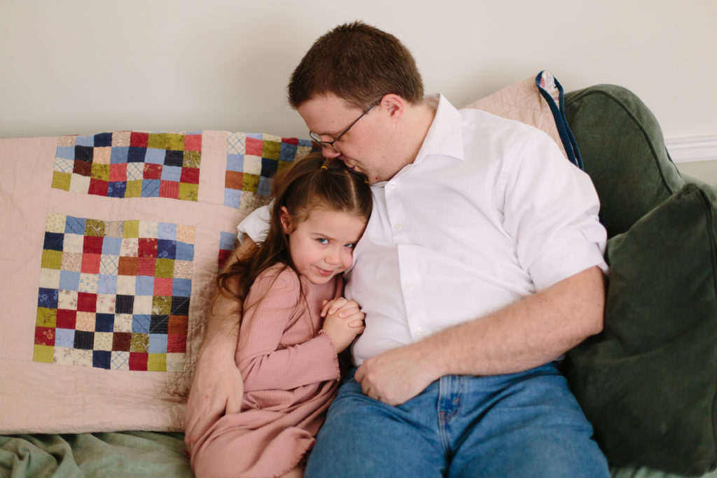 lifestyle newborn session dad snuggling with daughter