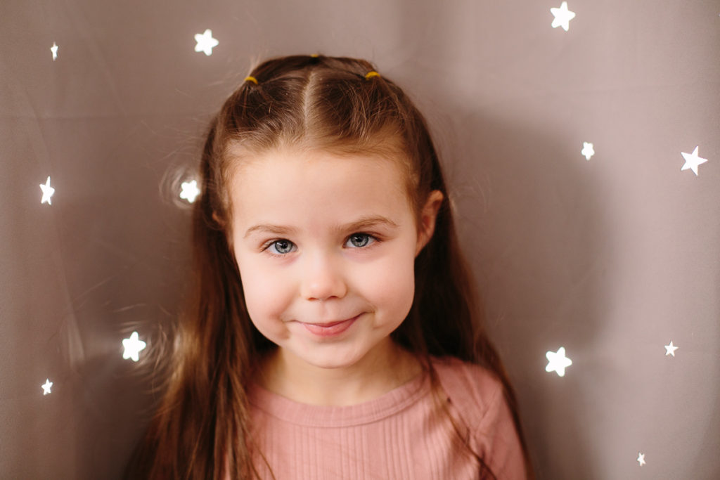 Little girl in front of starlight curtains
