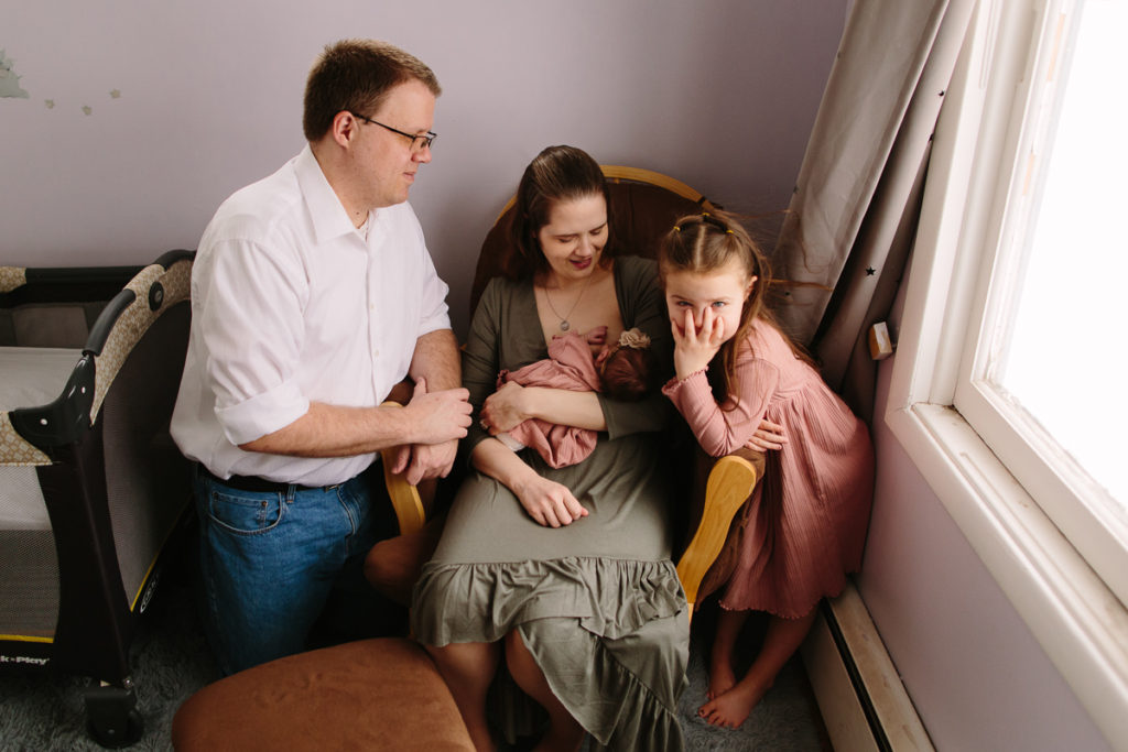 family hanging out with mom while breastfeeding baby