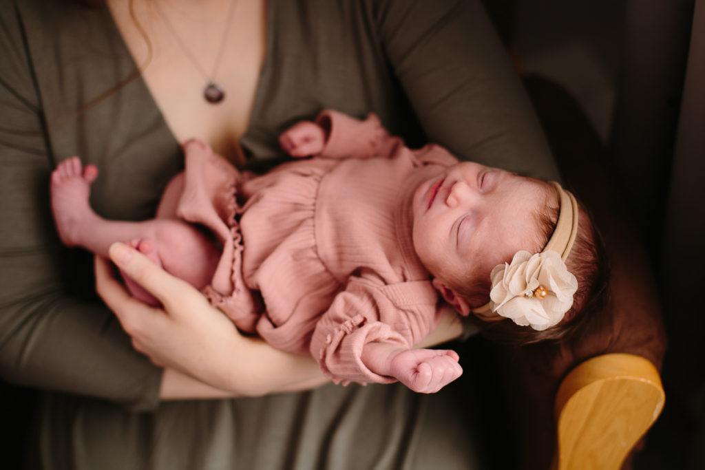 lifestyle newborn session baby girl sleeping in moms arm