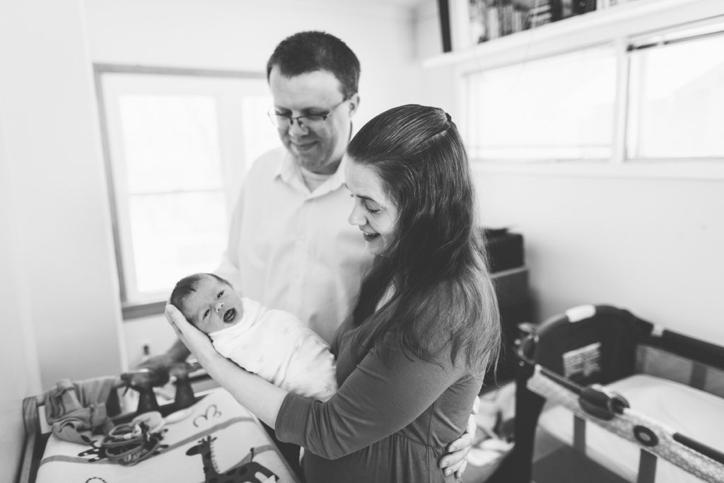 mom swaddling newborn baby girl lifestyle newborn session