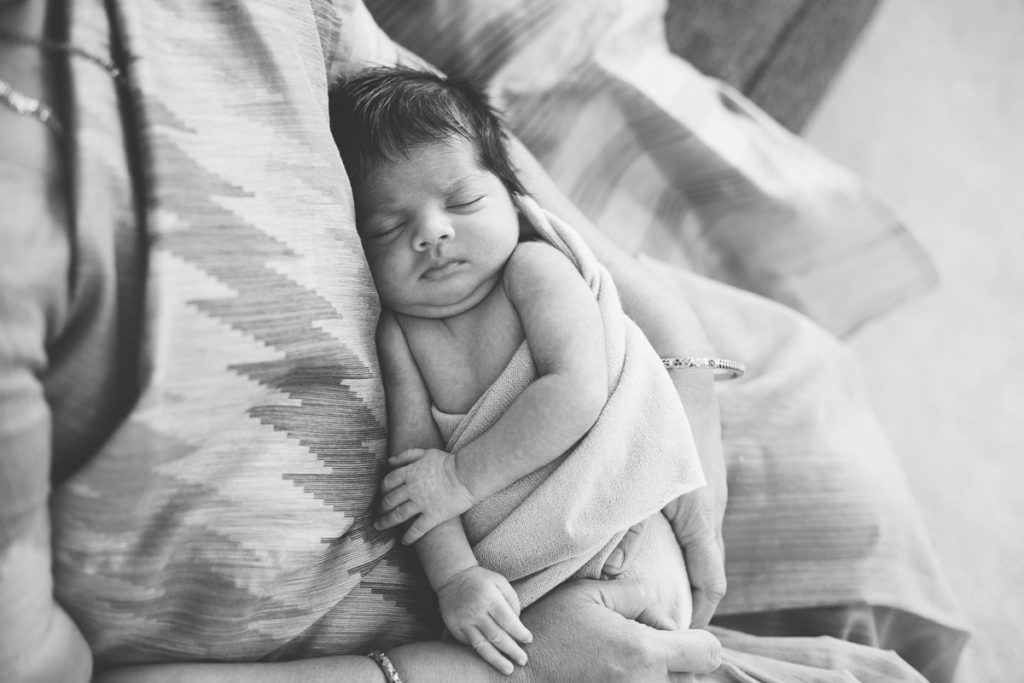 newborn baby girl sleeping on grandmas lap
