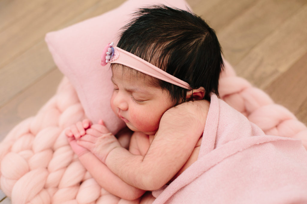 newborn baby girl in pink with dark hair