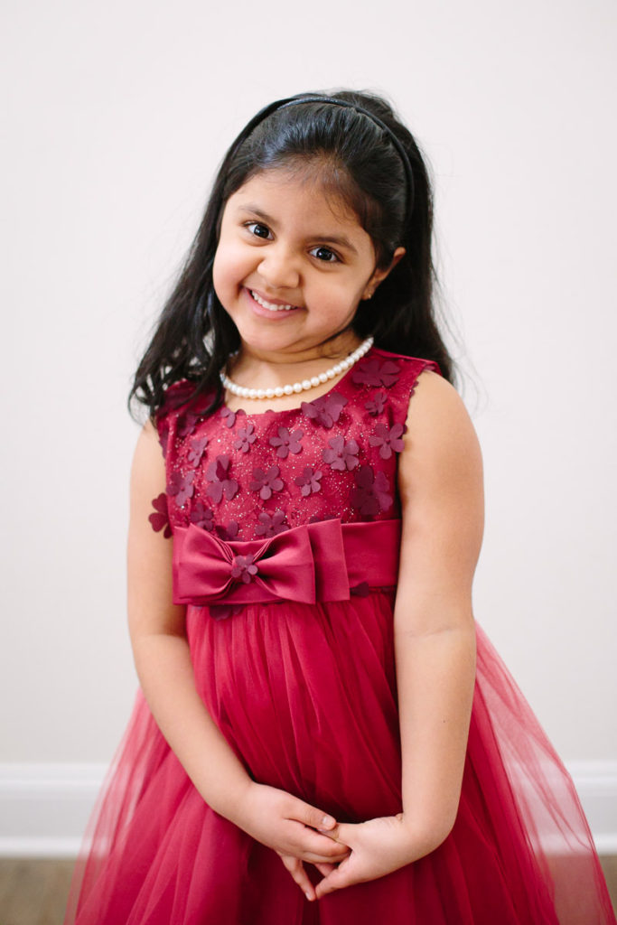 little girl in red dress in her clifton park home