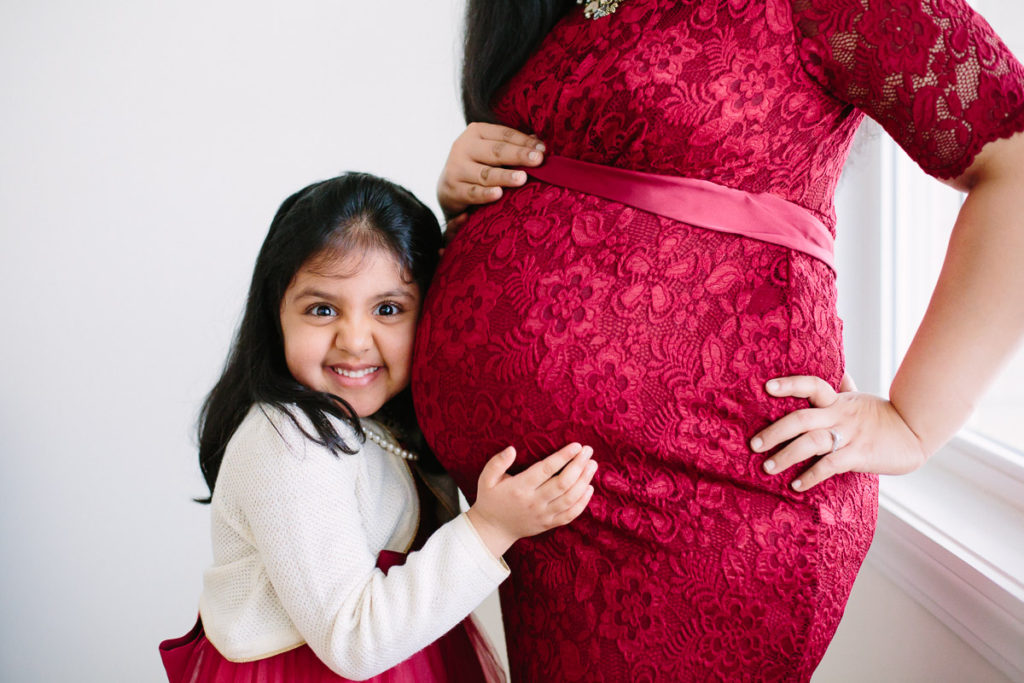 little girl hugging moms pregnant belly maternity photographer