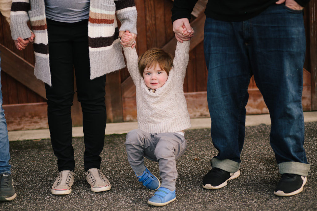 mom and dad holding toddler arms Clifton park NY
