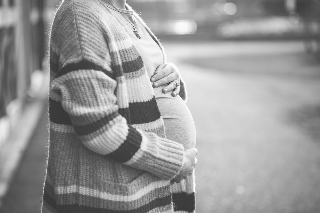 mom holding baby belly in stripped sweater