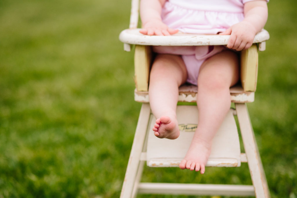 baby sits in doll high chair in Garnsey Park NY