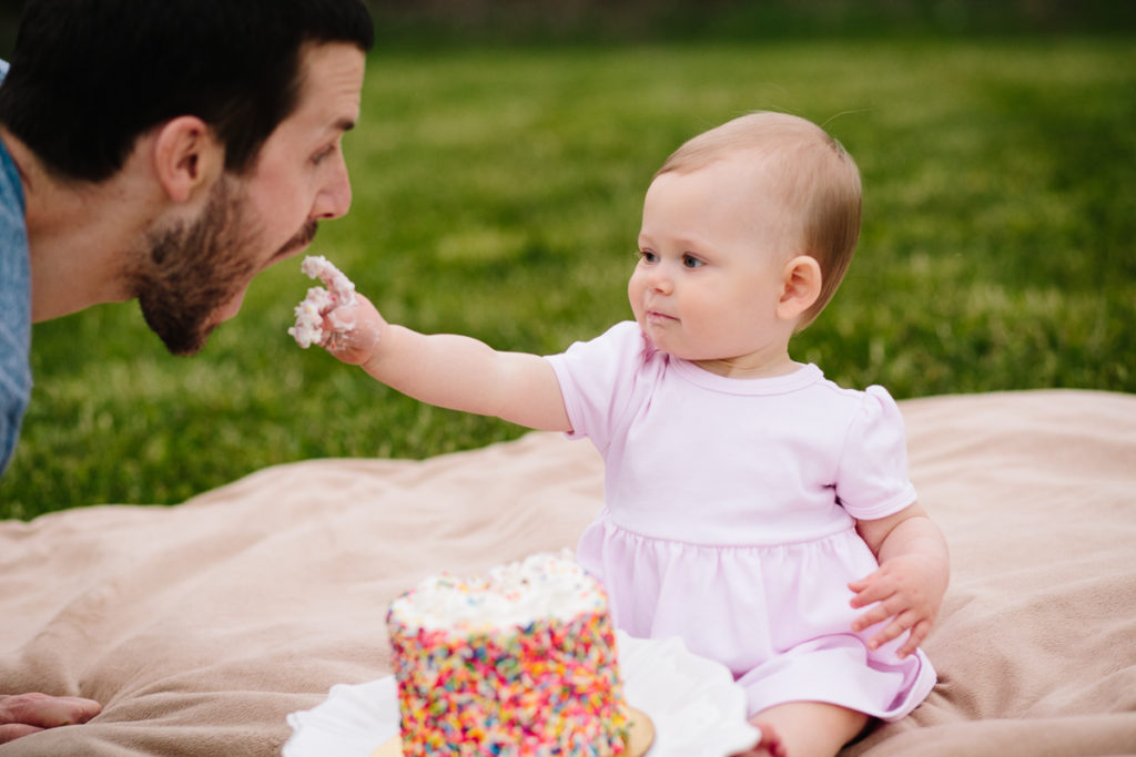 Saratoga NY baby photography giving daddy a bite of cake