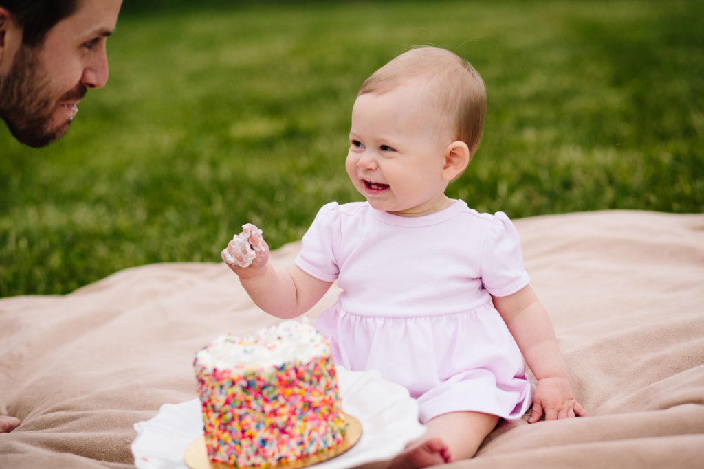 smiling at dad after giving bite of cake