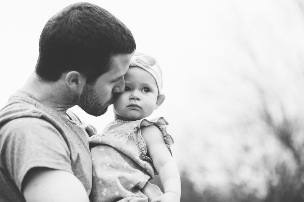 Dad giving baby girl kiss on a cheek