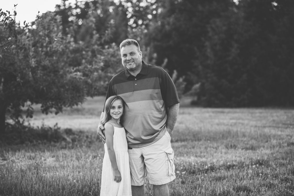 daughter in white dress with dad black and white