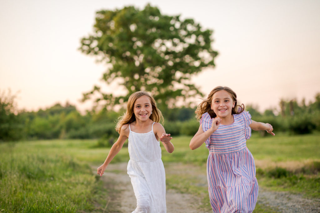 twin sisters running through an apple orchard Clifton Park NY