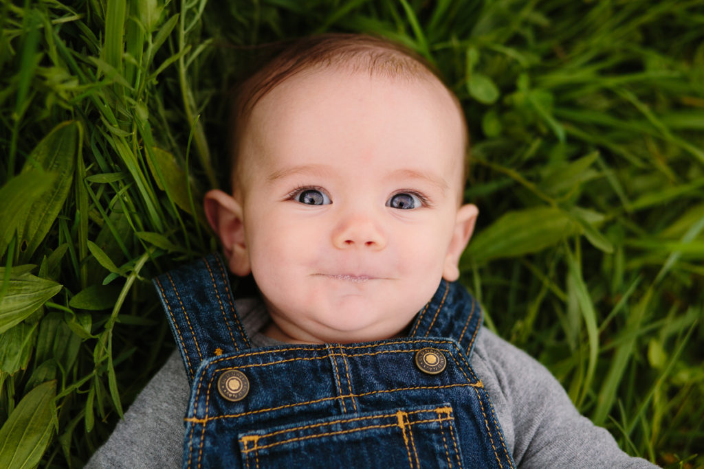 baby boy with blue eyes laying on grass clifton park ny