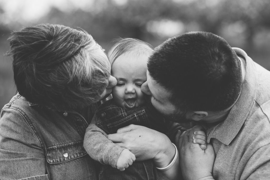 mom and dad kissing baby boy face clifton park ny