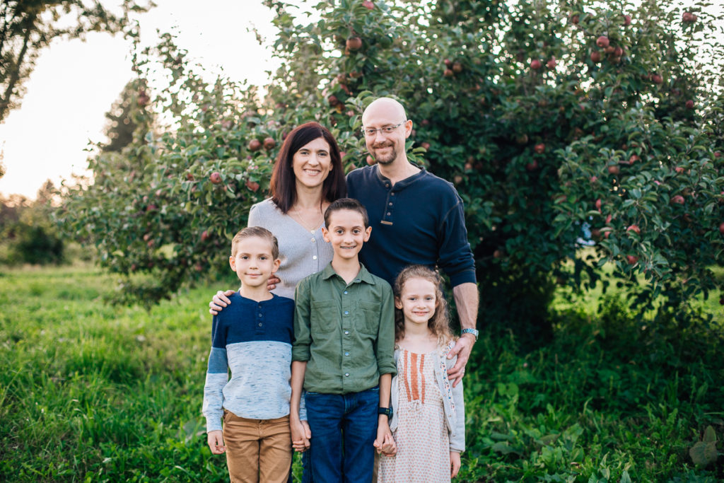 family in front of apple tree at riverview orchards