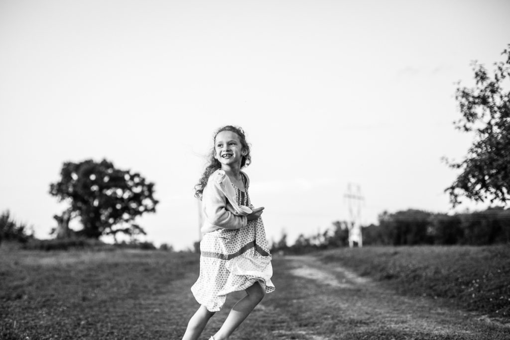 little girl with long curly hair running