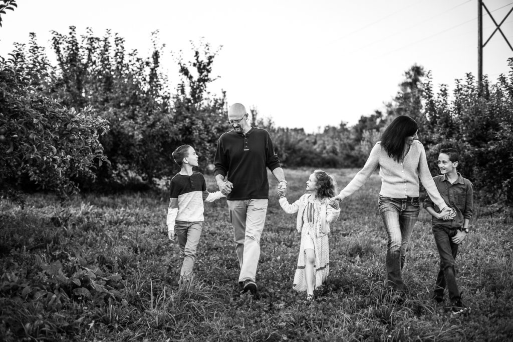 black and white picture of family walking in orchard
