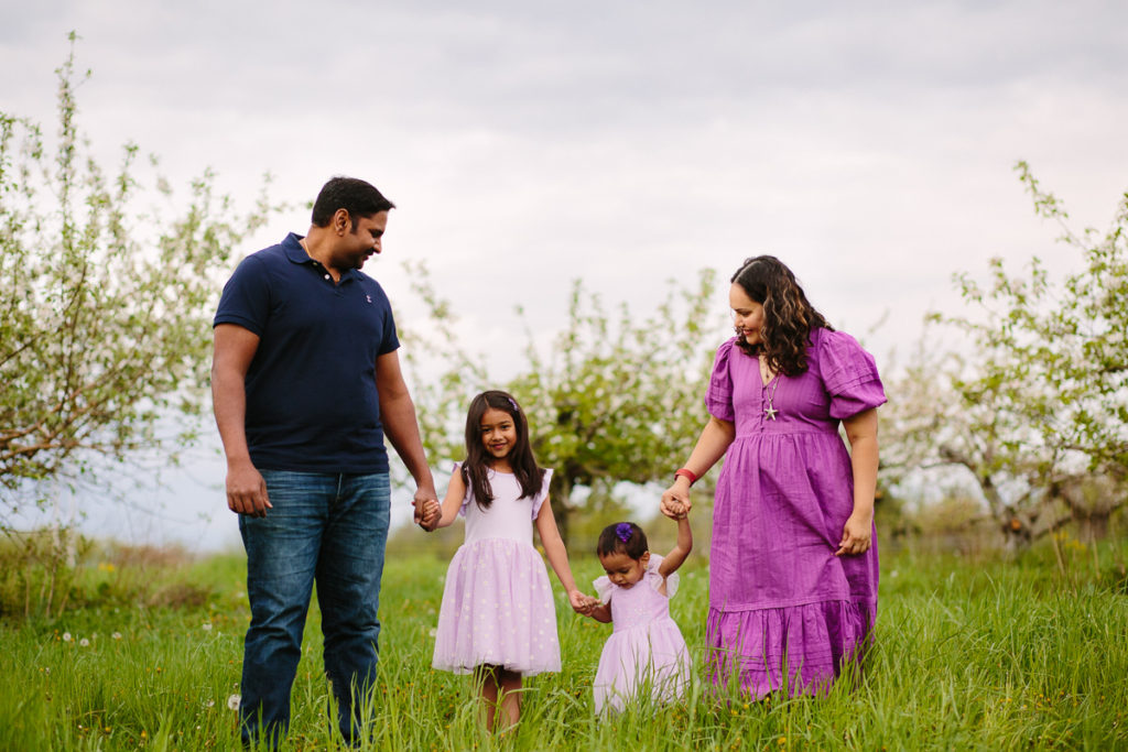family walking in apple blossoms Saratoga NY family photographer